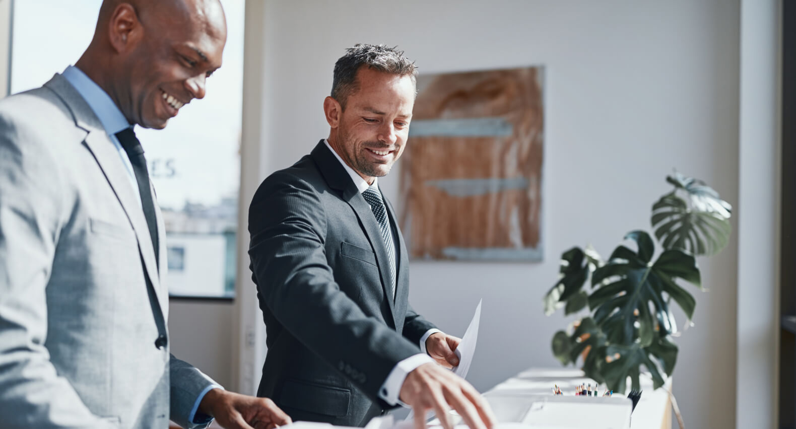 Two men wearing a suit at a table.